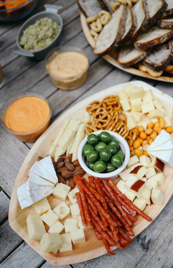 A rustic platter with an assortment of cheeses, meats, nuts, and olives, perfect for gourmet snacking.