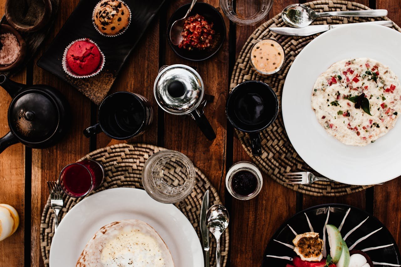 A beautifully set table featuring various dishes, drinks, and stylish ceramic tableware.